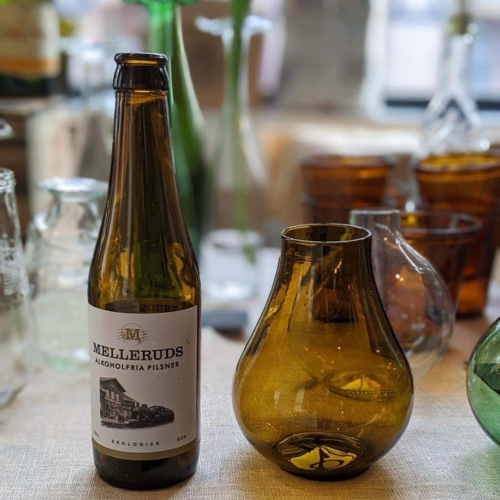 Brun glasvas bredvis glasflaska i samma färg